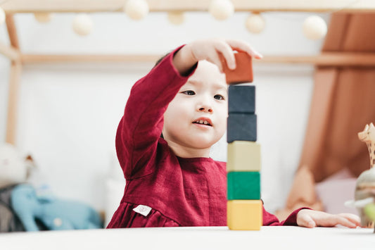 Niño jugando con bloques de madera, juguetes educativos para su edad